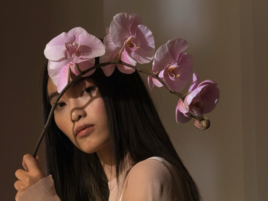 a photo of a woman holding a flower captured on an iPhone 16 Pro