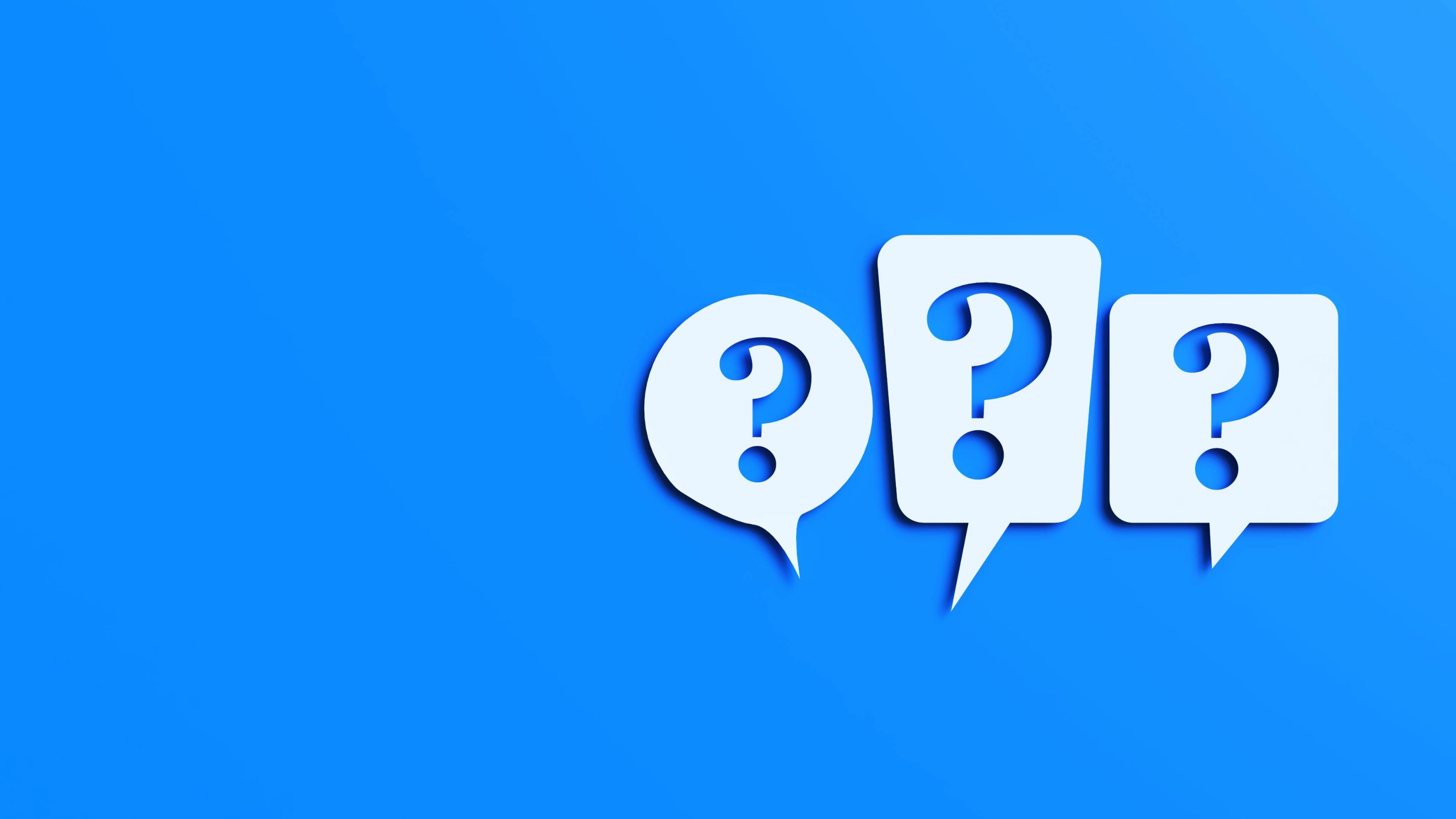 Three question marks cut out of white speech bubbles on blue background