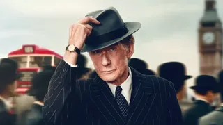 An image from the movie Living, one of the best new Hulu movies this December, showing Bill Nighy's character wearing a hat and walking through London