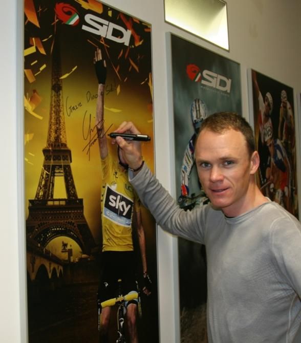 Chris Froome autographs a poster