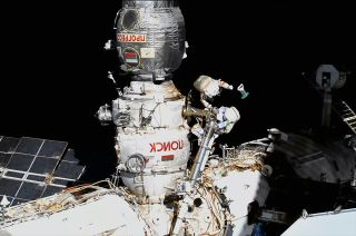 Roscosmos cosmonaut Oleg Artemyev releases the first of 10 small satellites during a spacewalk with European Space Agency (ESA) astronaut Samantha Cristoforetti outside of the International Space Station on Thursday, July 21, 2022.