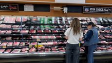 Shoppers look through the meat section at a grocery store in Los Angeles. 