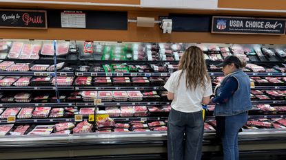 Shoppers look through the meat section at a grocery store in Los Angeles. 