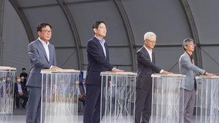 Four Samsung executives standing in front of clear perspex podiums with their hands placed on top