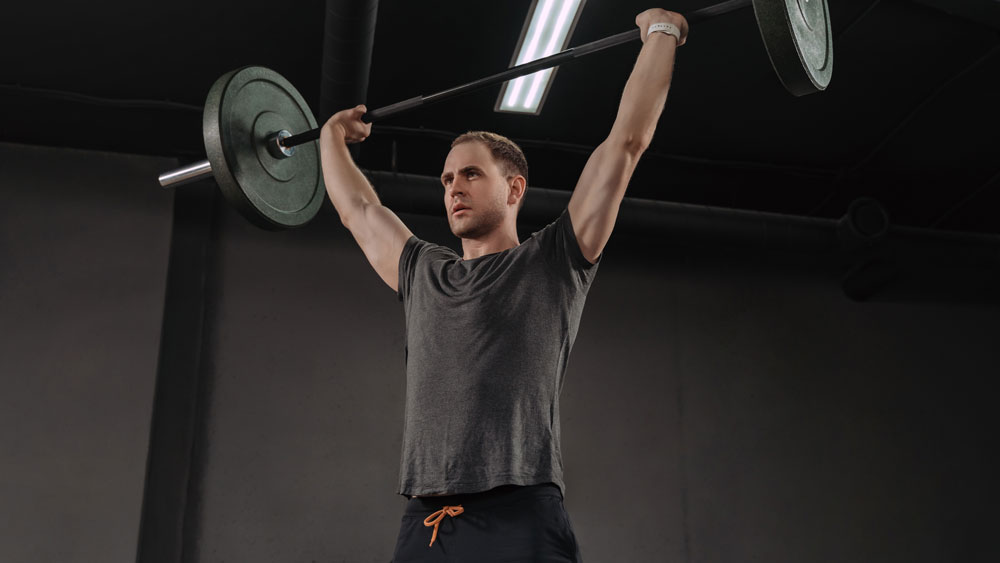 Man performs military press exercise