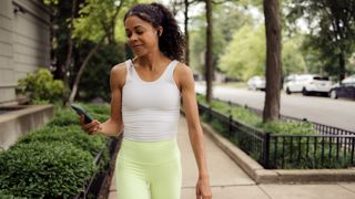 a woman walking and looking at her phone