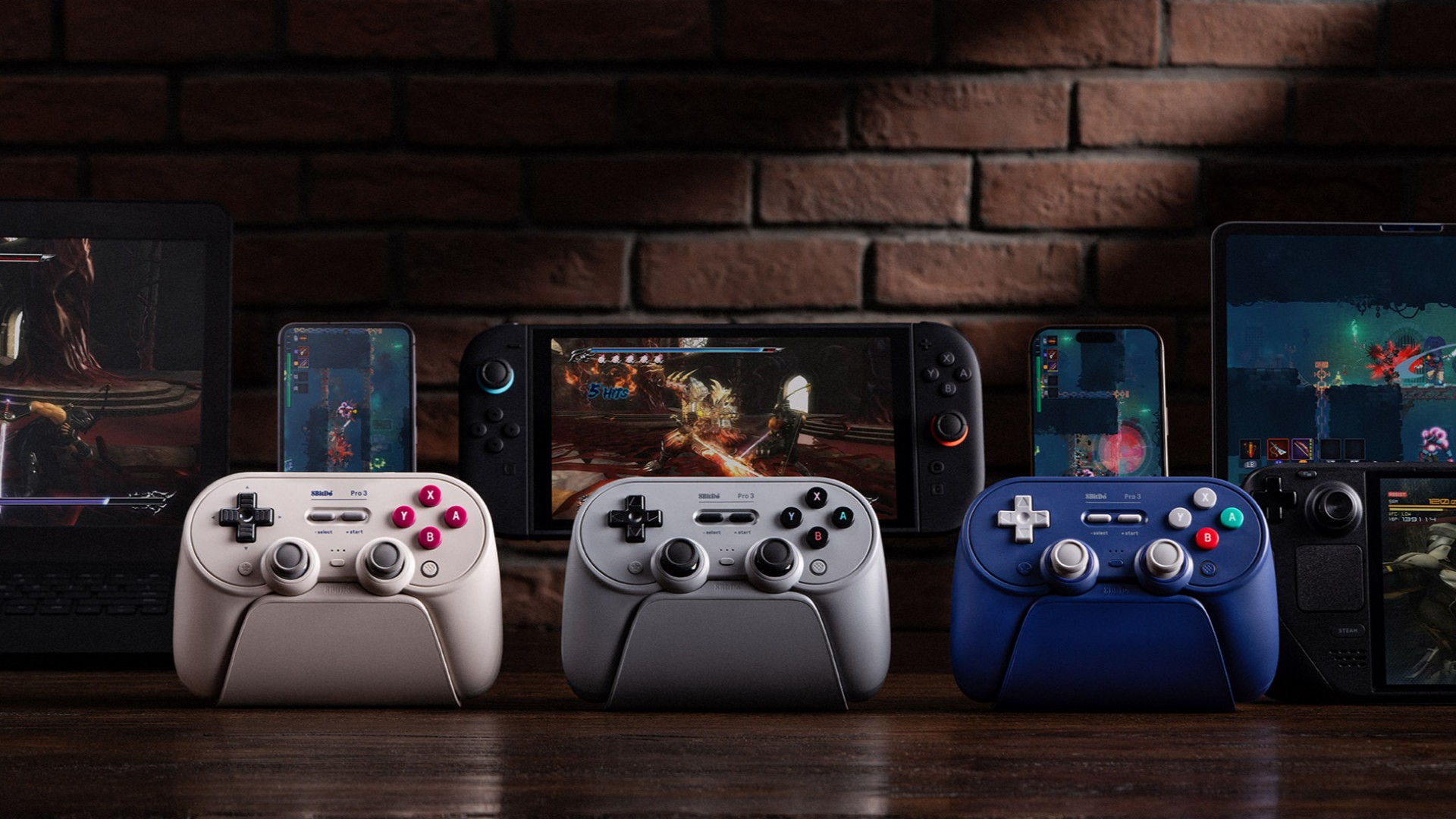Three 8BitDo controllers in front of a Nintendo Switch 2 console on a wooden desk