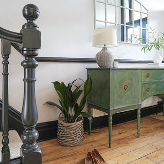 hallway with grey staircase and green cabinet