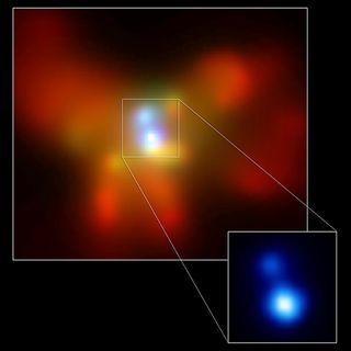 A blurry photo of red and orange blobs against a black background, with glowing blue blobs in the middle