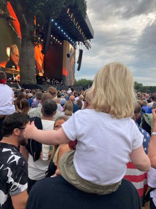 Small boy watches Bruce Springsteen in a festival crowd