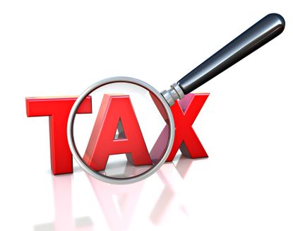 the word tax in red letters under a magnifying glass