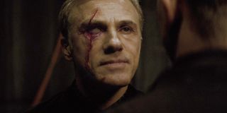 Christoph Waltz stares at Daniel Craig, boasting with a new facial scar, in Spectre.