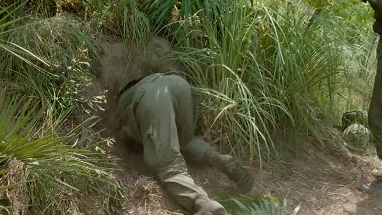 The behind of a man crawling into a tunnel in Vietnam