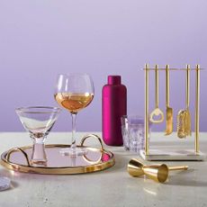 cocktail glasses with burgundy bottle and blue wall
