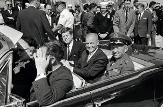 President John F. Kennedy and Mercury astronaut John Glenn ride together in a parade celebrating Glenn's historic orbital flight in February 1962.