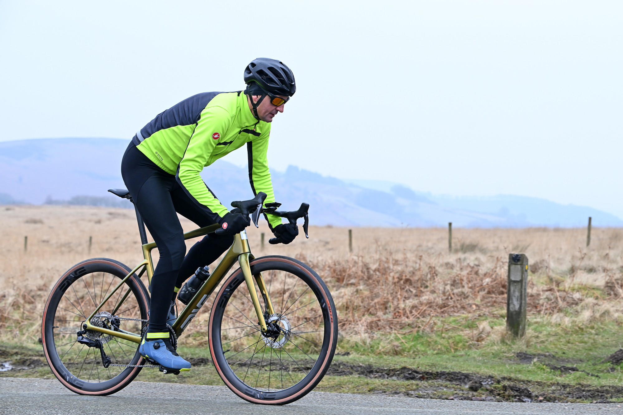 Man in a flouro top riding an ENVE Fray bike on a road in the Peak District
