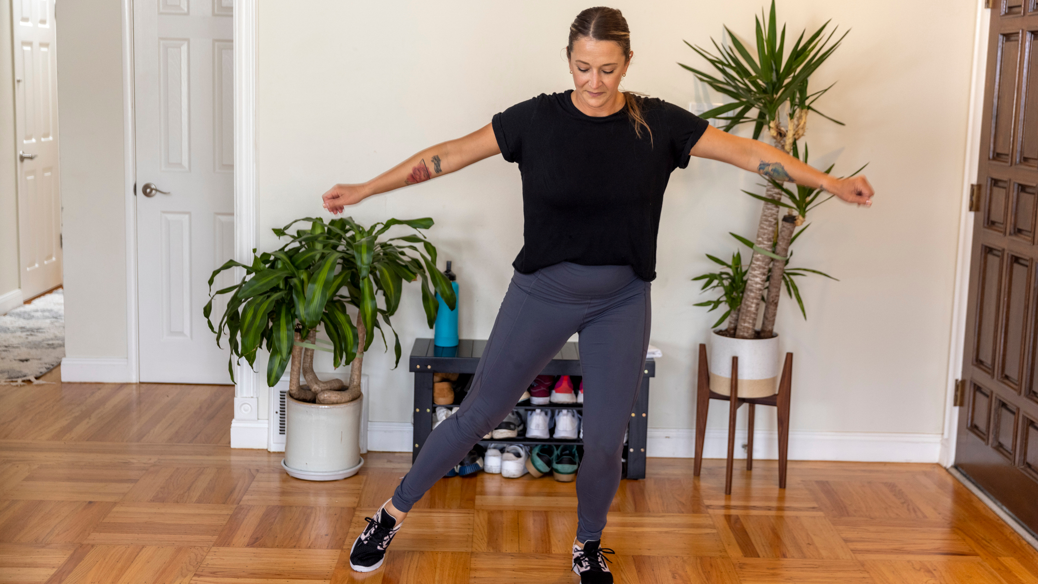 Woman balancing on one foot at home
