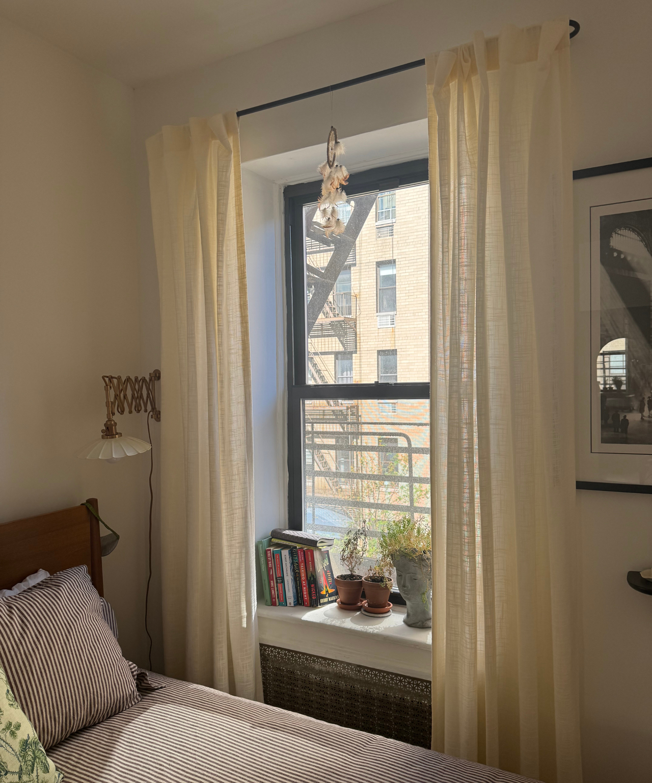 a bedroom with sheer curtains in front of the windows