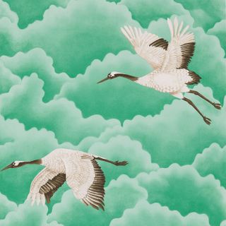 White and grey cranes flying in green and white clouds