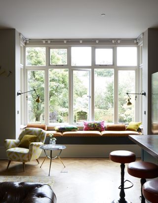 Window seat in bay window with colourful kitchens