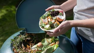 woman composting food waste into a compost bin