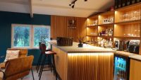 A bar inside an outbuilding with lighting illuminating the cabinets