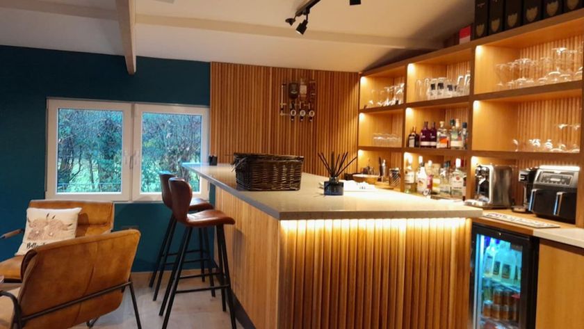 A bar inside an outbuilding with lighting illuminating the cabinets