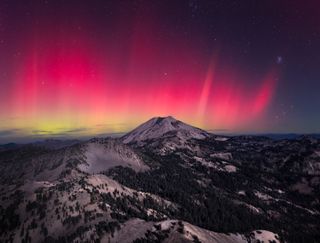 A photograph of the northern lights over mountains in California