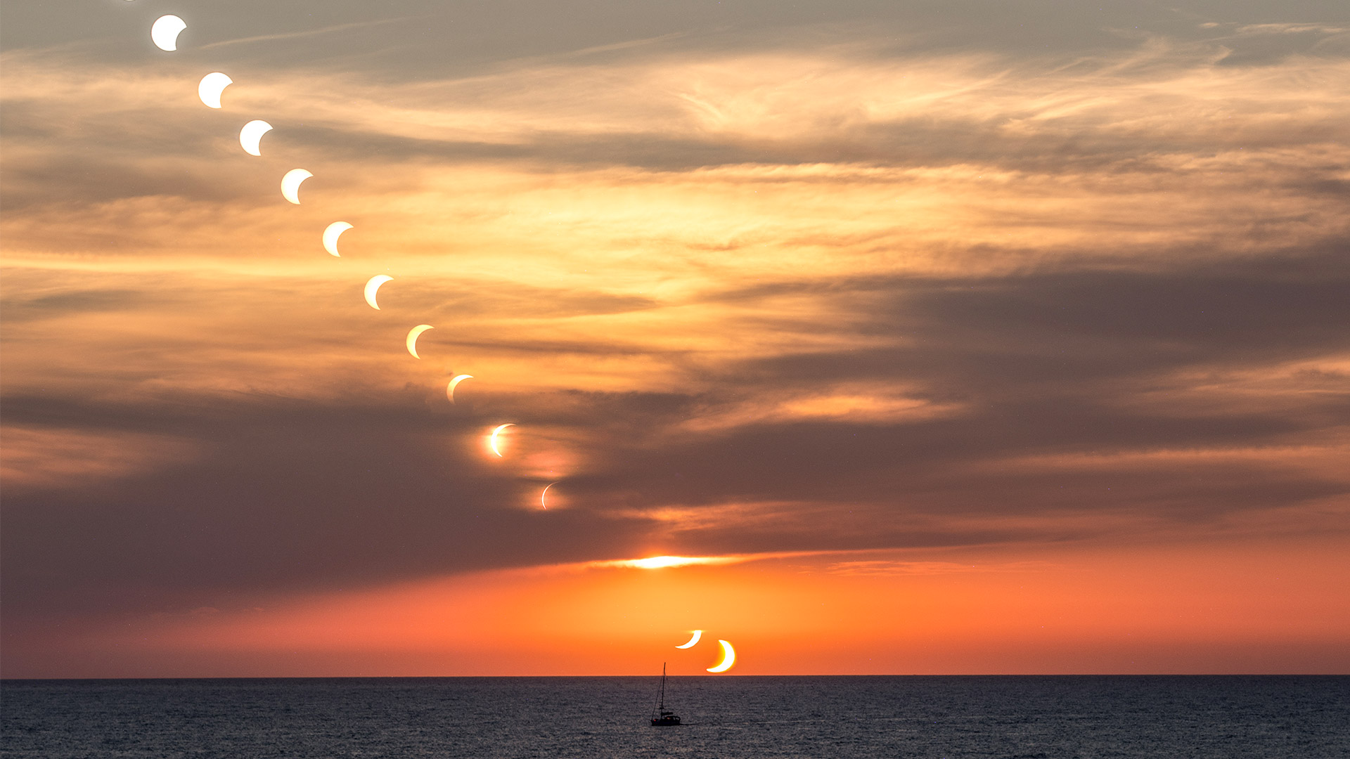 A mutliexposure shot of the solar eclipse over the Mediterranean sea in Mallorca Spain with a boat in the foreground