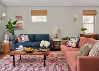 living room with pink and blue sofas and wooden coffee table with fruit