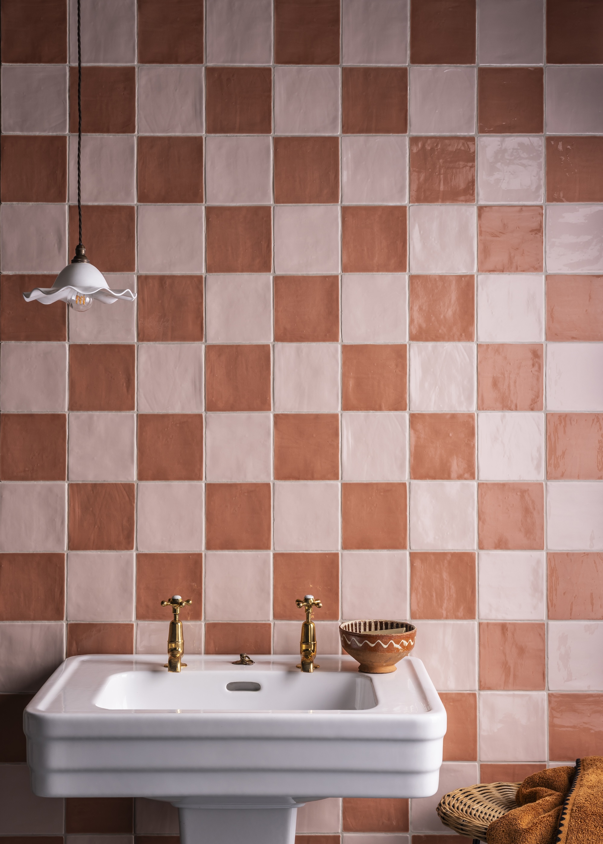 a orange and pink checkerboard wall in a bathroom above a basin