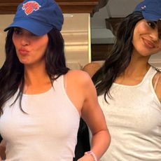 Kendall jenner wears a white hanes tank top, knicks hat, and leather pants.