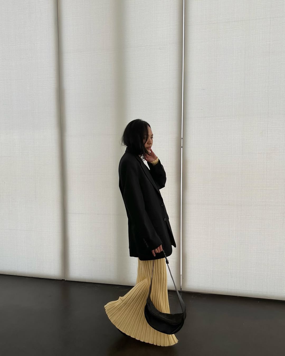 Dawn in a blazer and pleated yellow skirt