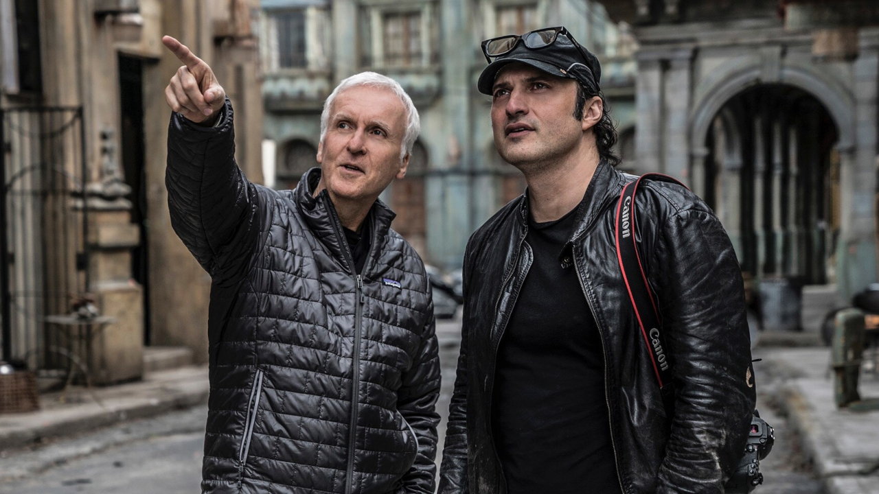 James Cameron points out a detail on the Iron City set to Robert Rodriguez in Alita: Battle Angel.