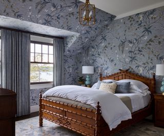 bedroom blue floral wallpaper dormer window lake view dark wood bedframe