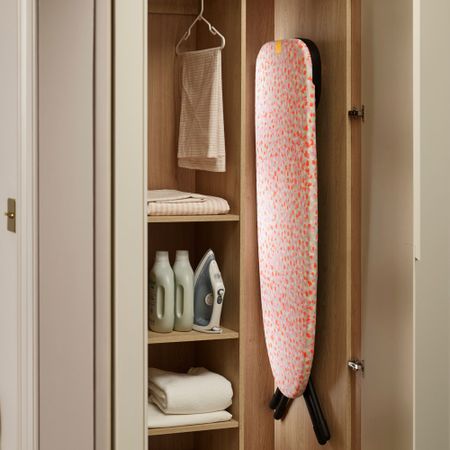 Ironing board hanging in cupboard