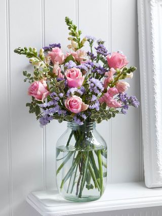 bouquet of flowers in glass vase next to white frame