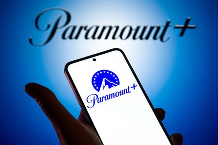 The Paramount Plus logo is displayed on a mobile phone with the company's branding seen in the background in this photo illustration in Brussels, Belgium, on November 8, 2025. (Photo by Jonathan Raa/NurPhoto via Getty Images)