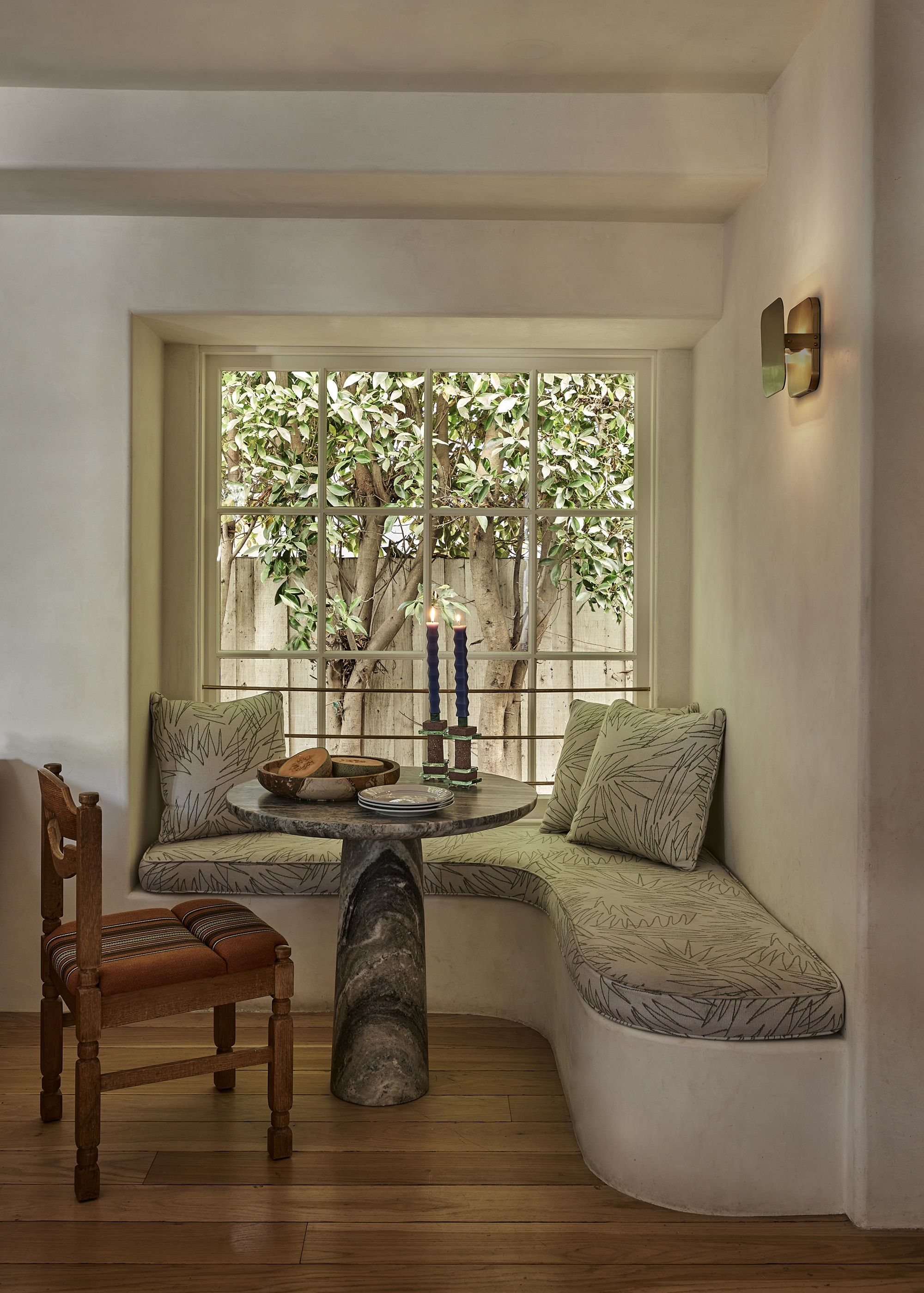 a dining room nook with a marble table and built in seat