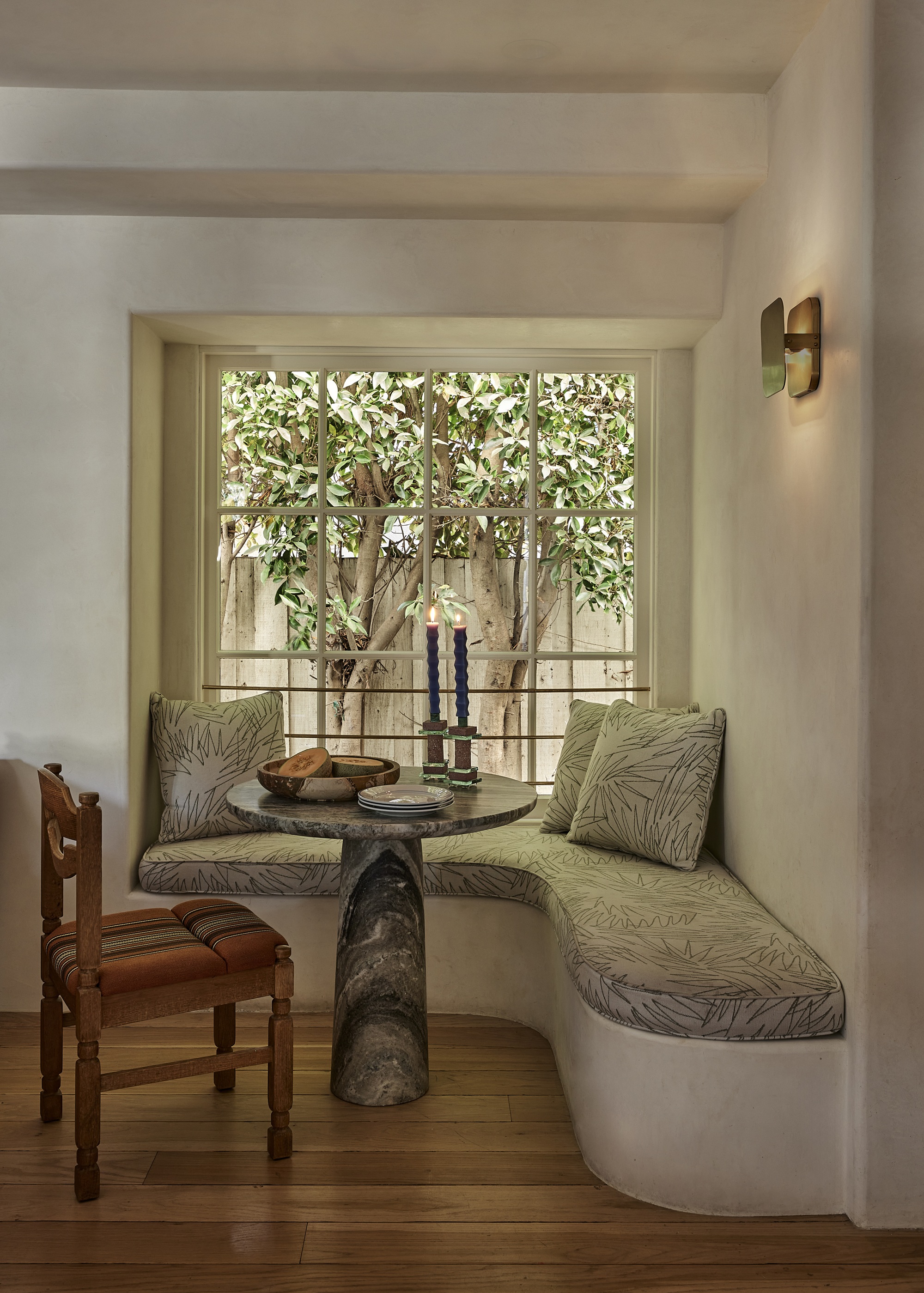 a dining room nook with a marble table and built in seat