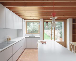white kitchen with terracotta flooring