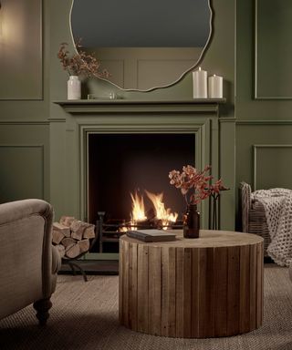 living room with green walls and painted fireplace surround