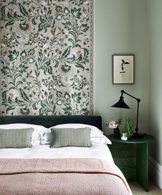 Simple bedroom ideas in a scheme with sage green walls, pink linen and a tapestry hung on the wall
