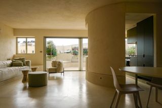 Jaffa Roofhouse by Gitai Architects - furniture to the left of the room. Open patio doors leading to a balcony area.
