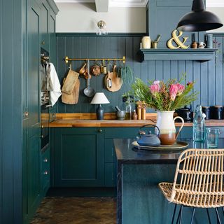 dark green kitchen with panelling and island