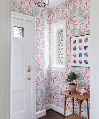 entryway with pink patterned wallcovering and stained glass window