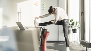 What is under desk exercise? image shows woman stretching at work