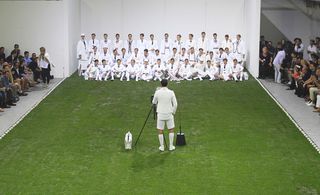 Models dressed in a contemporary take on cricket clothing marched across an AstroTurf field - with lines of cricket balls outlining its edge
