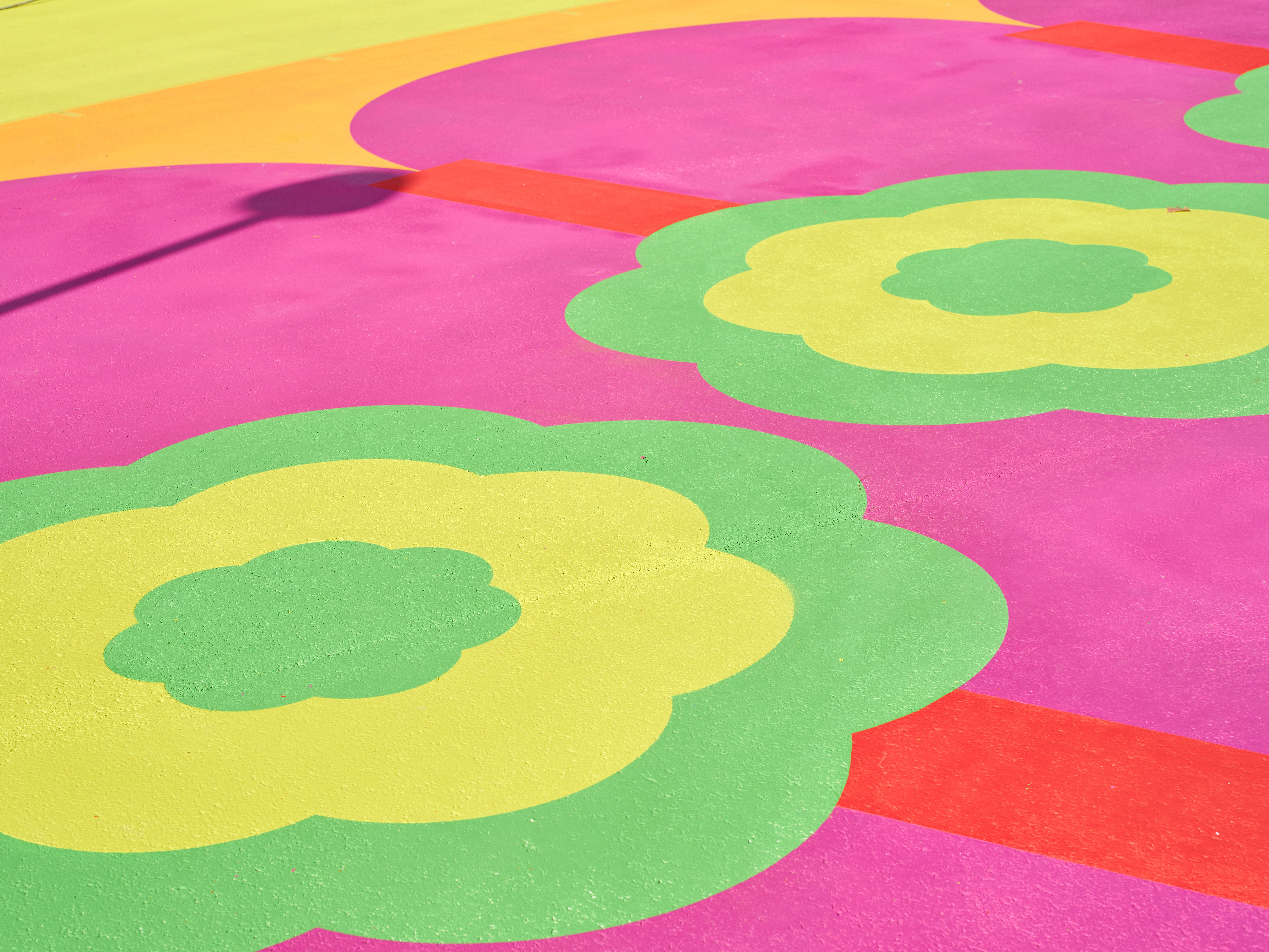 Aerial view of a colorful mural in pink, green, yellow, and red tones.