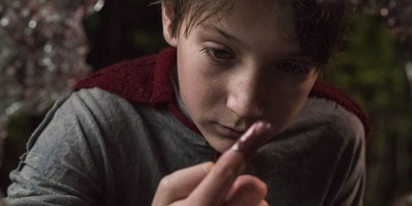 Jackson Dunn as Brandon Breyer looking at his bloody finger in Brightburn